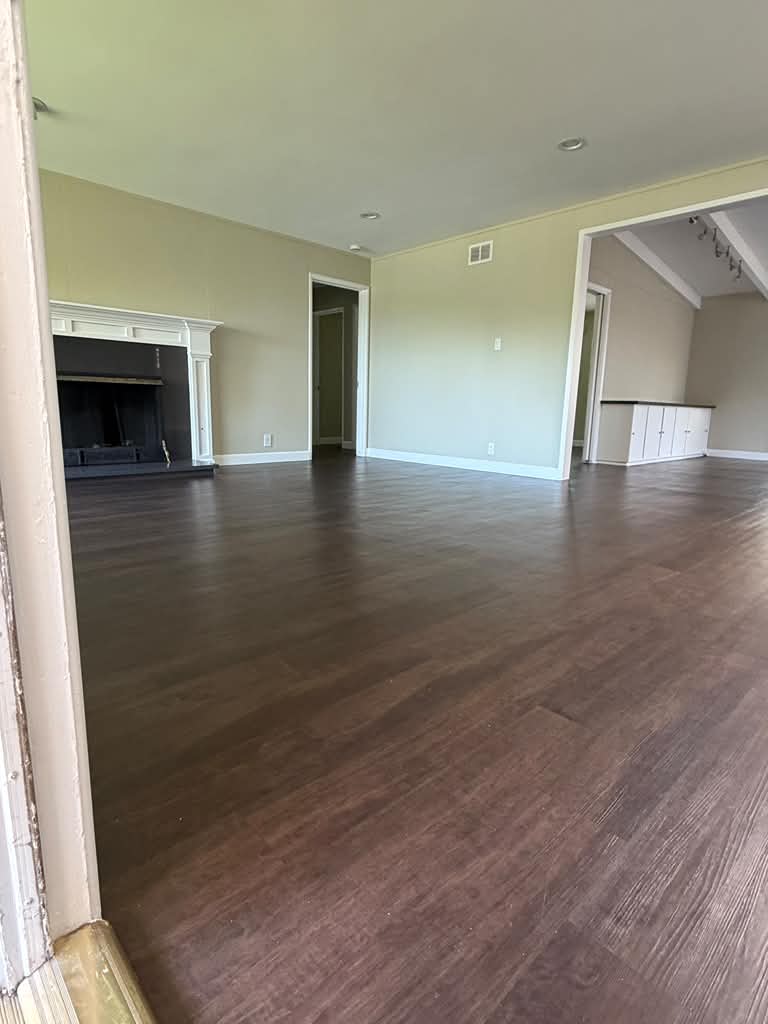 Empty living room with polished dark floors after remodeling